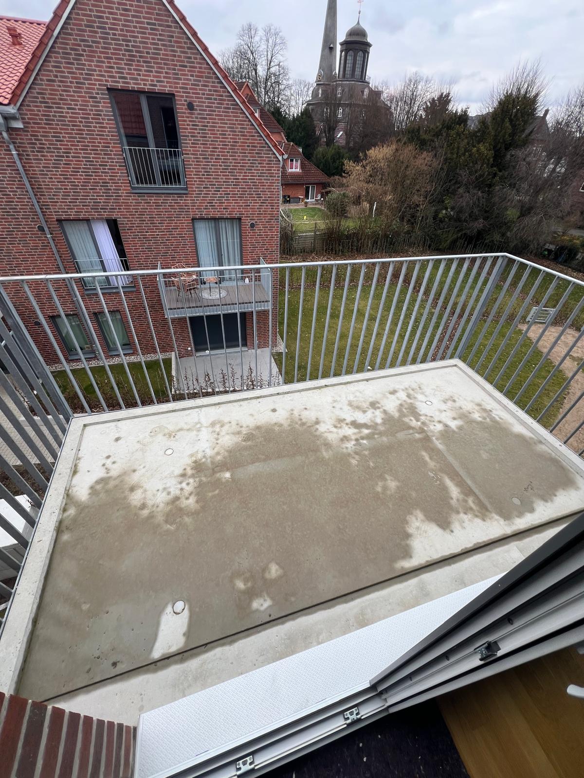 Balkon vor der Sanierung: rissiger und fleckiger Beton mit Algen und Verfärbungen