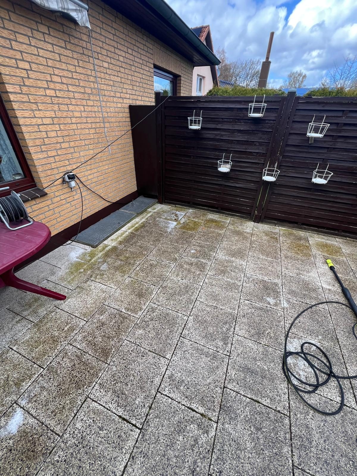 Terrasse vor der Reinigung: vermooste, dunkle Steinfläche mit Algenbelag